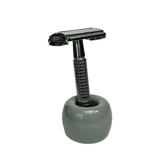 Grey ceramic toothbrush holder holding a short-handled safety raxzor
